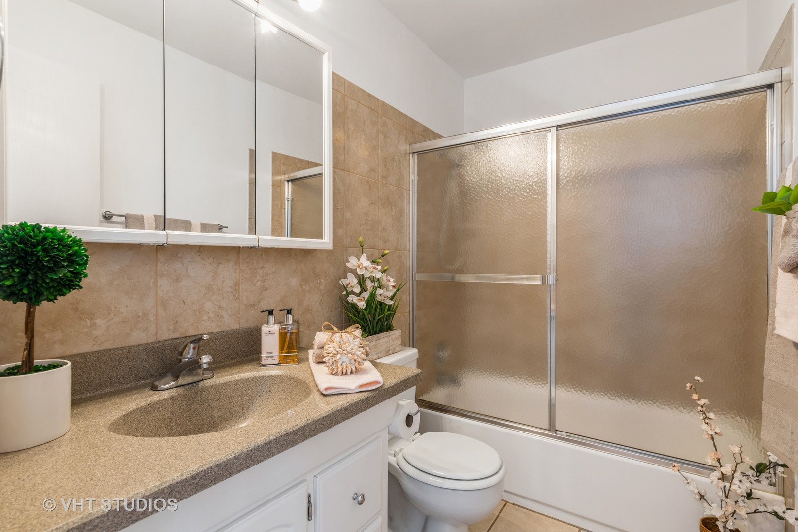 2205 West Nichols Road, Unit F Arlington Heights, IL 60004 - Photo 11 of 15 a bathroom with a granite countertop sink a toilet and shower