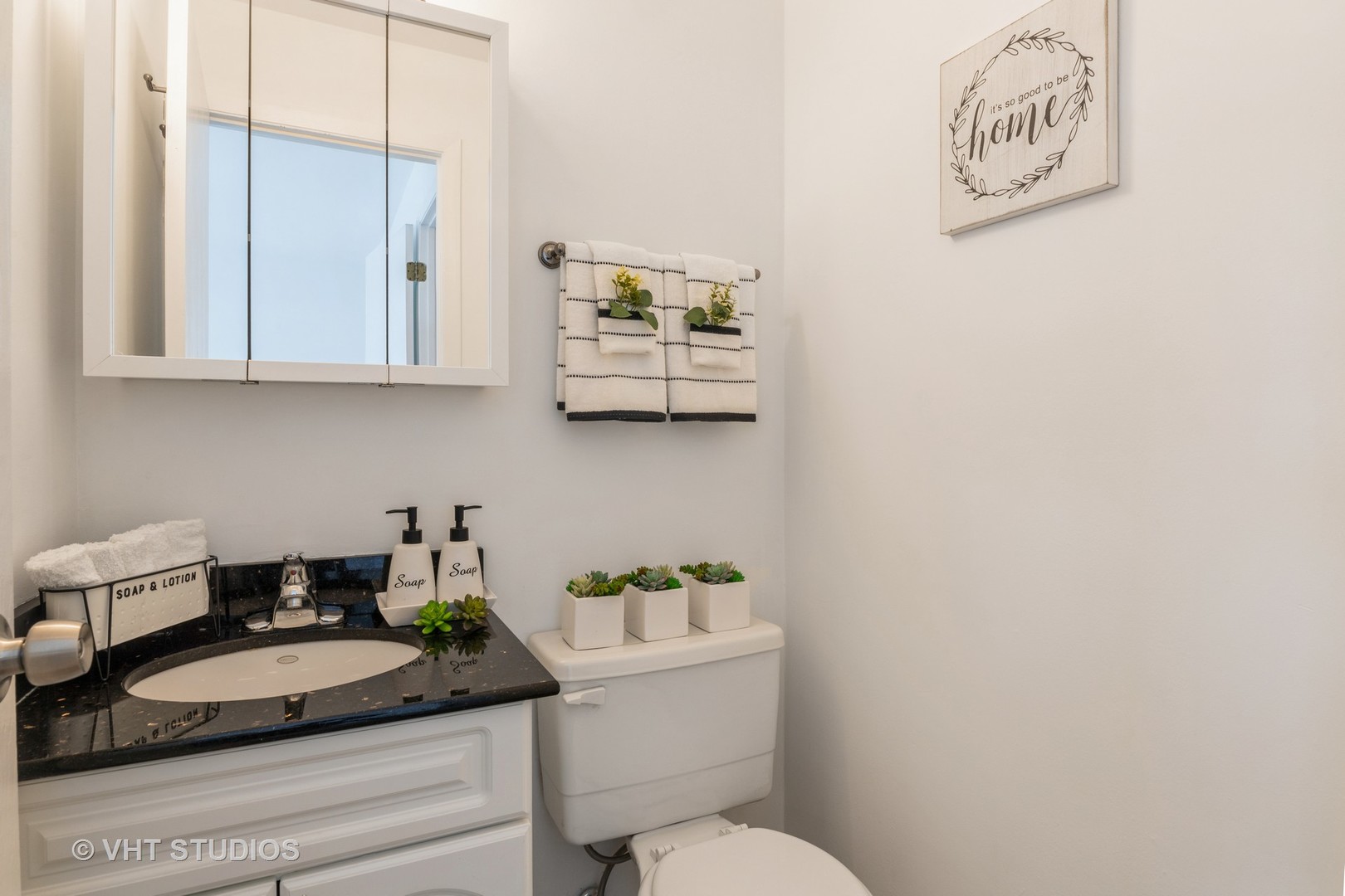 2205 West Nichols Road, Unit F Arlington Heights, IL 60004 - Photo 12 of 15 a bathroom with a granite countertop sink a mirror and a toilet