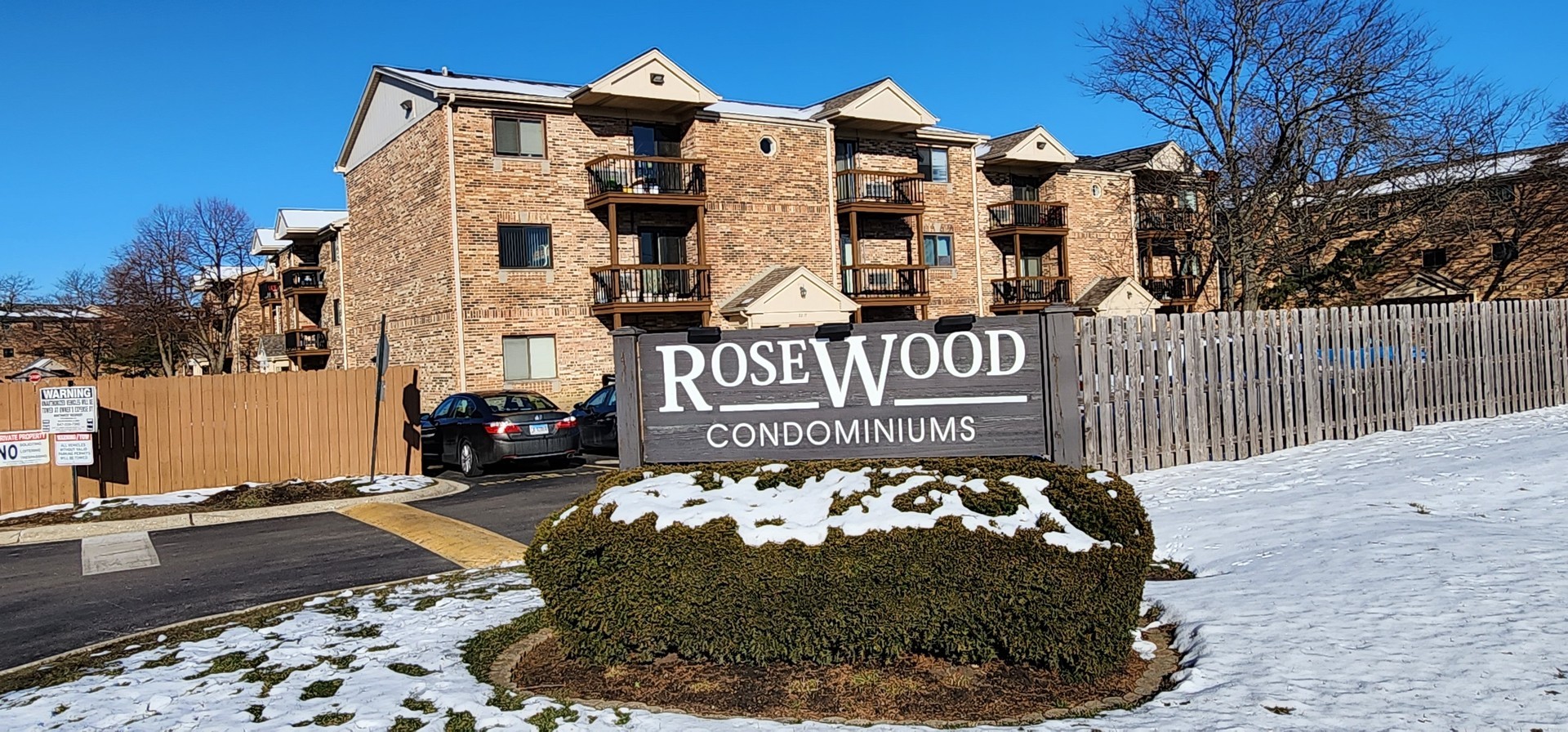 2205 West Nichols Road, Unit F Arlington Heights, IL 60004 - Photo 15 of 15 a view of a white house with large trees and wooden fence