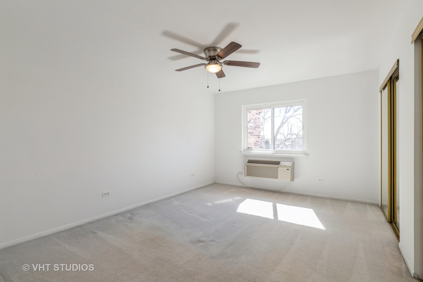 2205 West Nichols Road, Unit F Arlington Heights, IL 60004 - Photo 9 of 15 an empty room with windows and fan