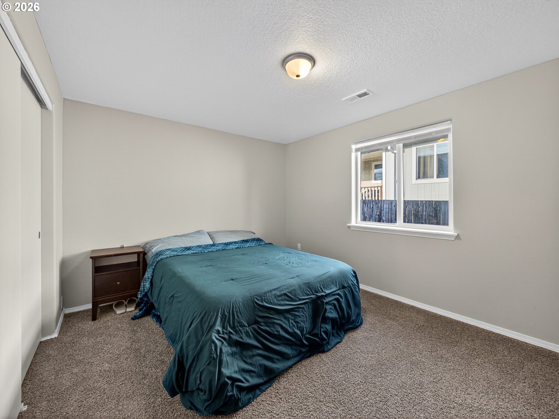 847 Northeast Duniway Road Lafayette, OR 97127 - Photo 20 of 38 a bed sitting in a bedroom next to a window and a chair