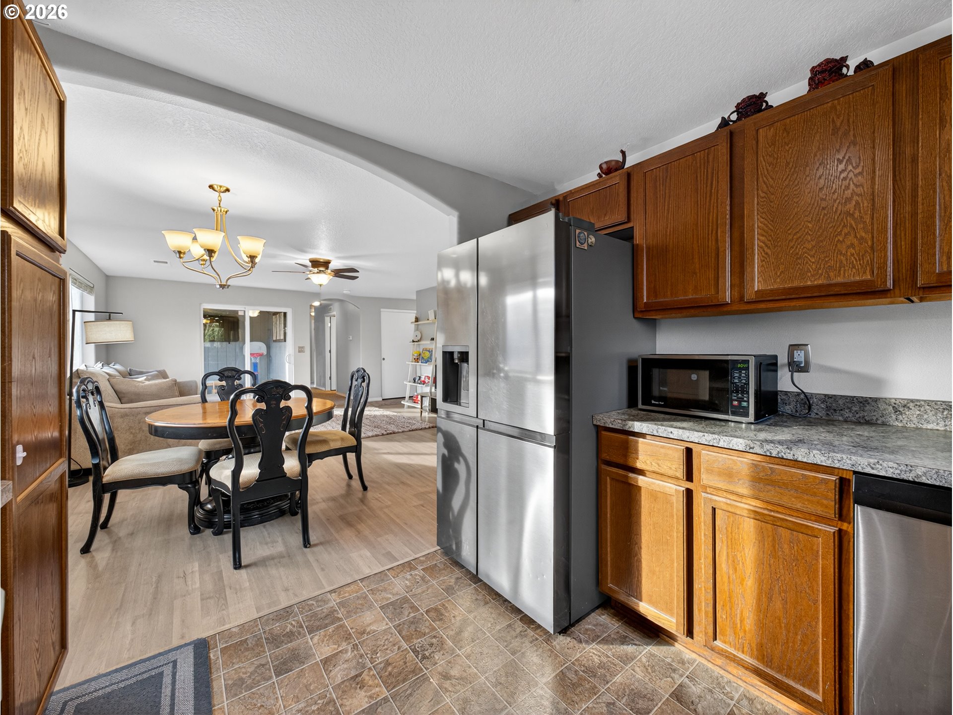 847 Northeast Duniway Road Lafayette, OR 97127 - Photo 9 of 38 a kitchen with stainless steel appliances granite countertop a refrigerator a stove a sink a dining table and chairs with wooden floor