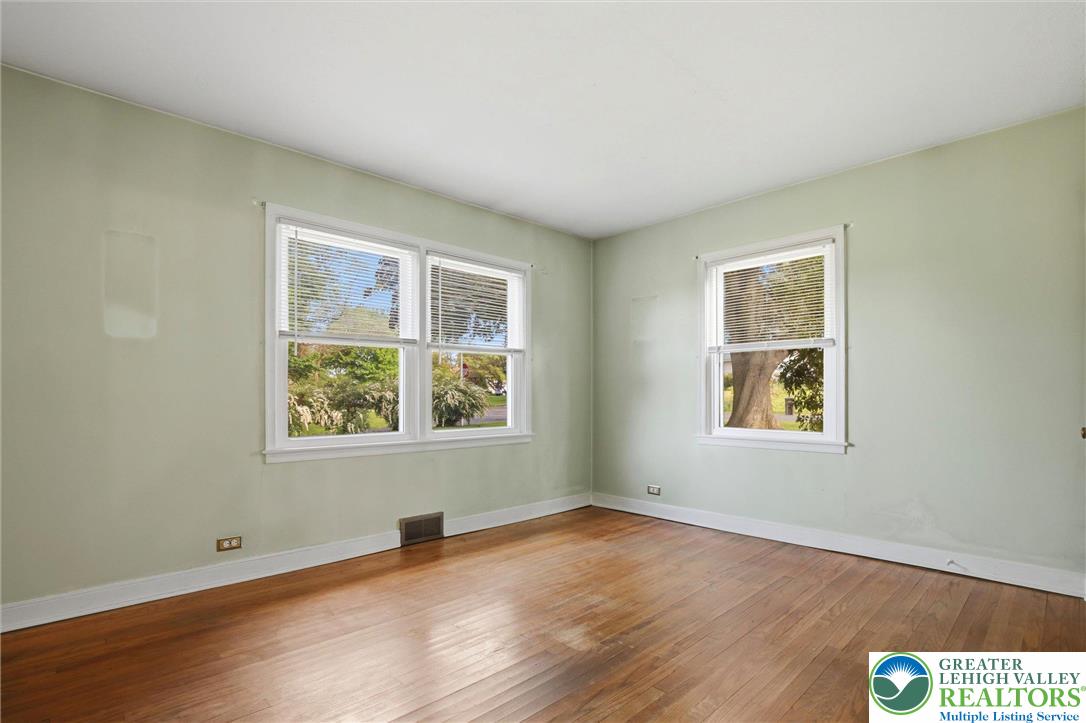 This bright room features beautiful wood floors and ample natural light from multiple windows.