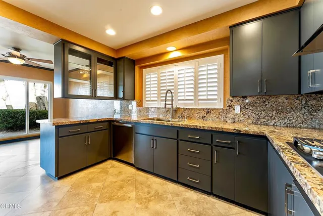 a kitchen with granite countertop sink and stove