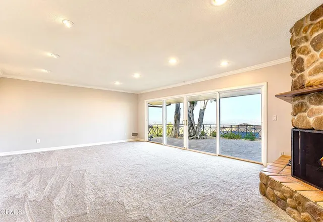a view of an empty room with a fireplace and a window