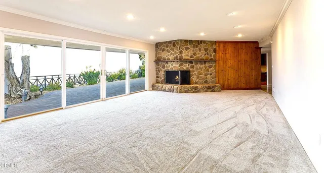 a view of an empty room with a fireplace and a large window