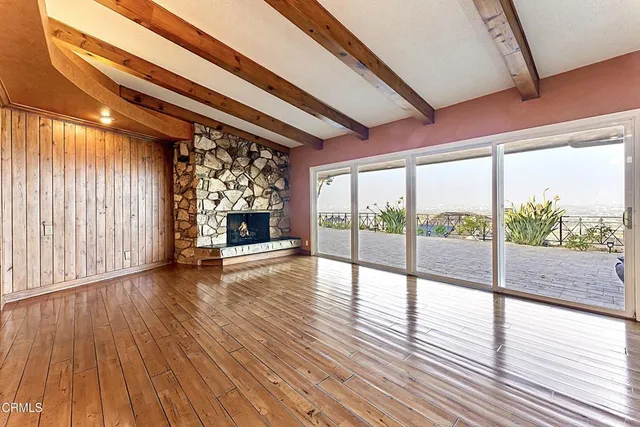 a view of empty room with wooden floor and fireplace