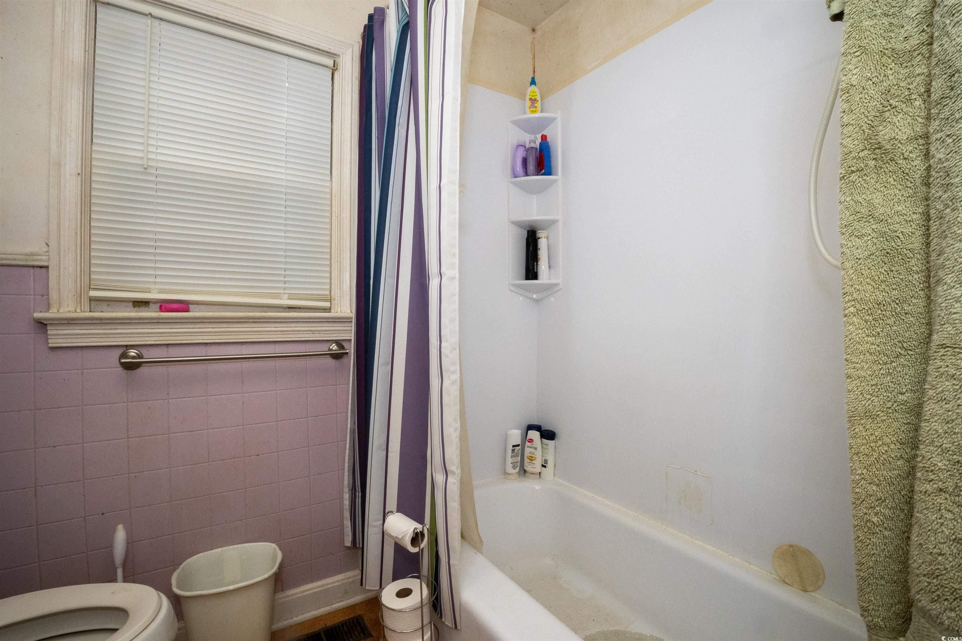 2405 South Island Road Georgetown, SC 29440 - Photo 17 of 24 Bathroom with toilet, tile walls, and shower / bath combo with shower curtain