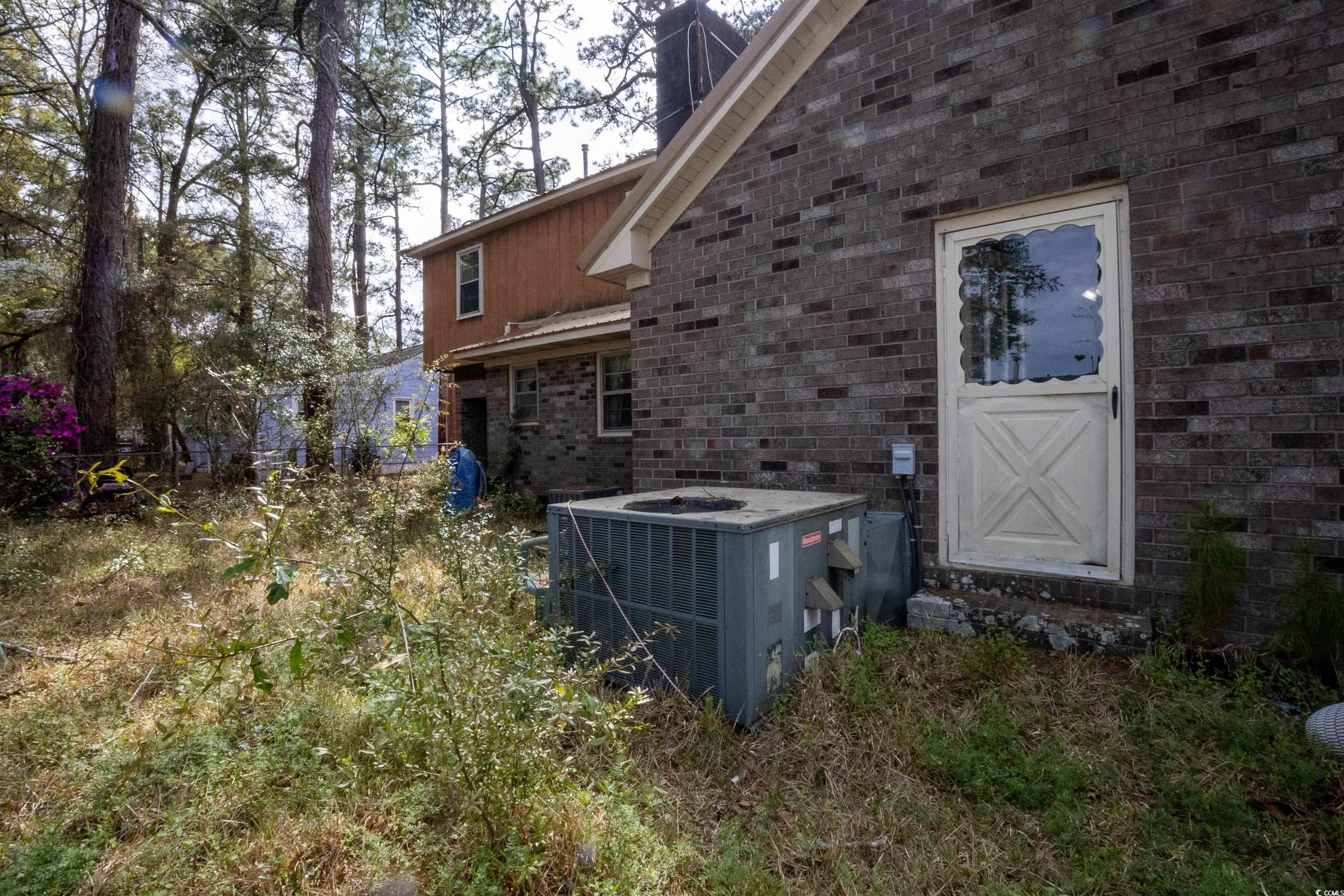 2405 South Island Road Georgetown, SC 29440 - Photo 20 of 24 Exterior space featuring brick siding, central AC, and metal roof