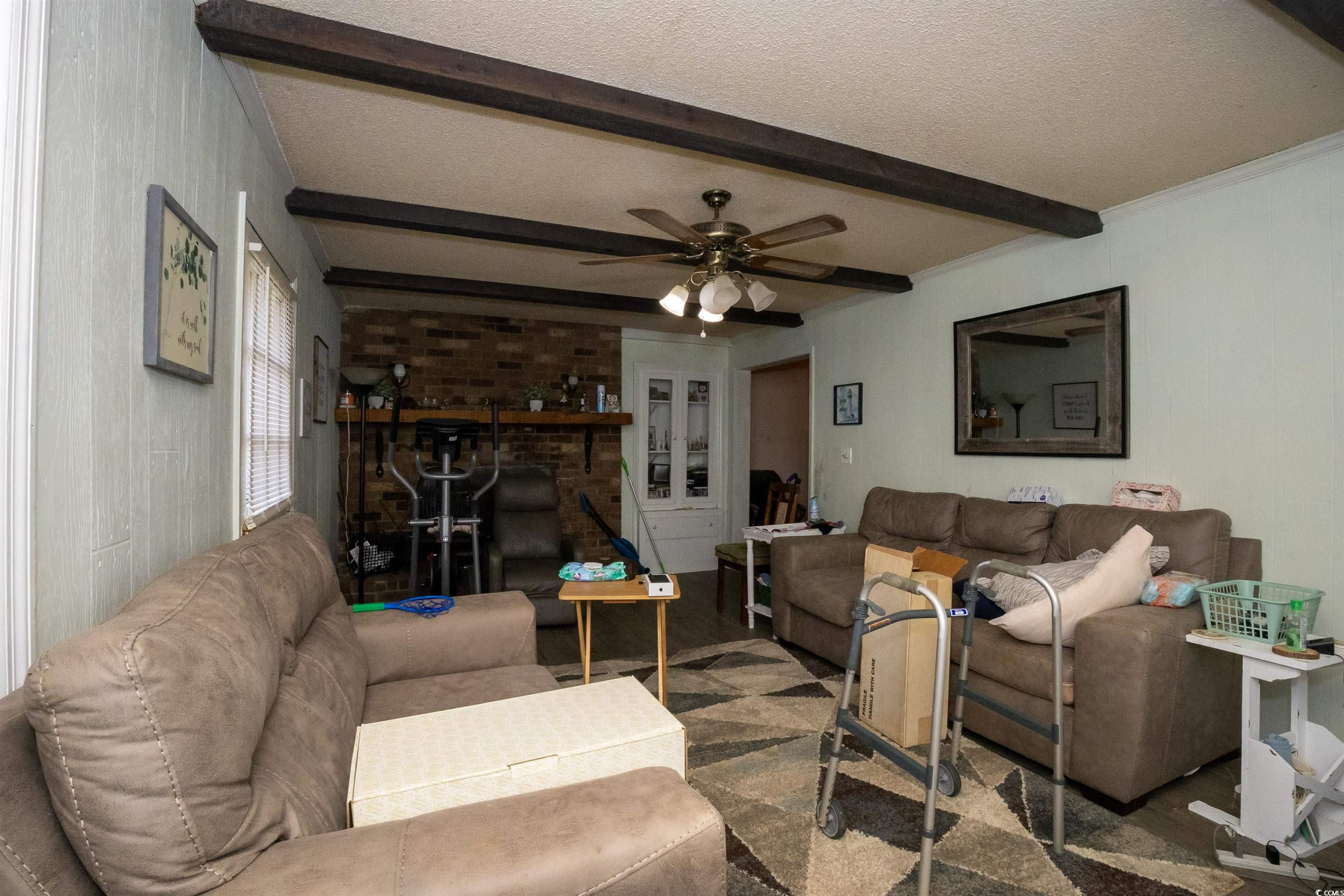2405 South Island Road Georgetown, SC 29440 - Photo 7 of 24 Living area featuring ceiling fan, beam ceiling, and a textured ceiling