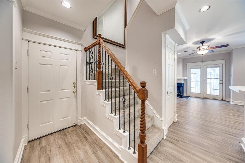 a view of a hallway with wooden floor and staircase