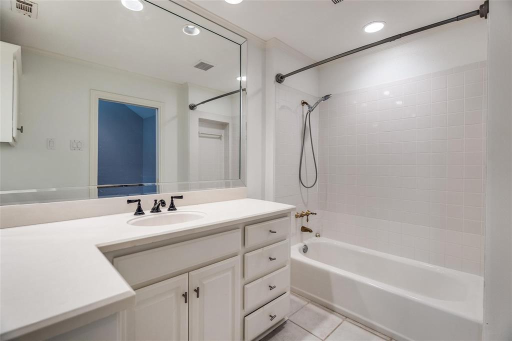 5325 Bent Tree Forest Drive, Unit 2244 Dallas, TX 75248 - Photo 10 of 15 a bathroom with a granite countertop sink a mirror a vanity and a bathtub