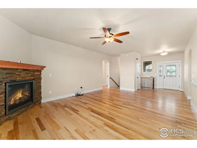 a view of empty room with wooden floor and fireplace