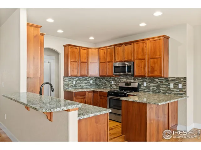 a kitchen with kitchen island granite countertop a stove top oven microwave and refrigerator