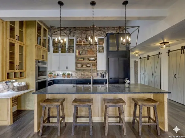 a kitchen with stainless steel appliances granite countertop a sink a stove and a refrigerator
