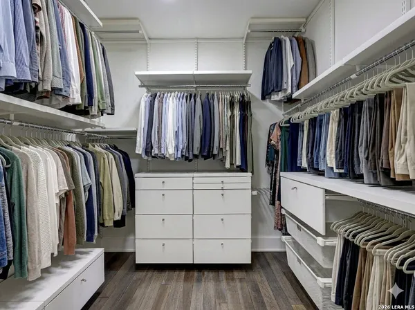 a view of walk in closet with clothes and shoes