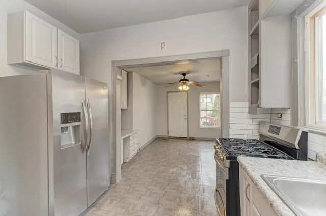 a kitchen with stainless steel appliances granite countertop a refrigerator and a stove