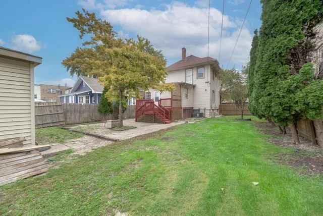 a front view of a house with garden and a tree