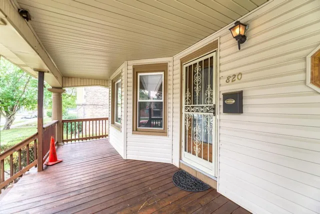 a view of a porch with wooden floor and floor to ceiling window