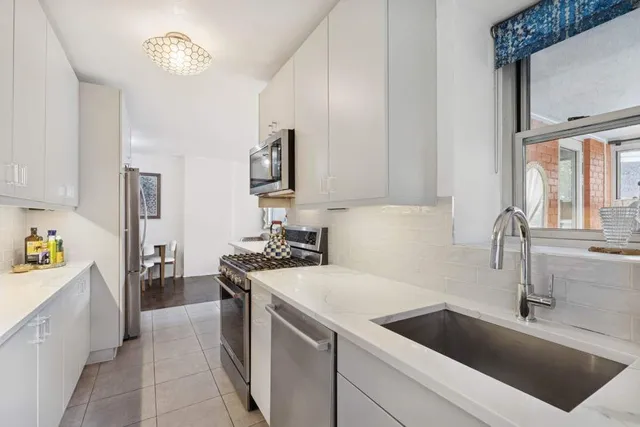 a kitchen with stainless steel appliances a refrigerator sink and stove