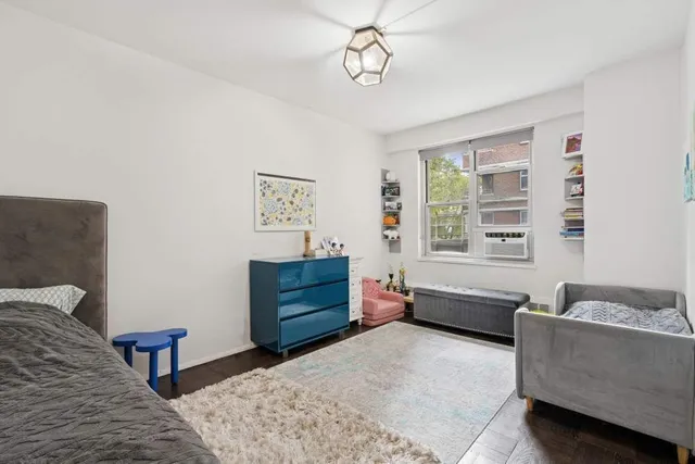 a spacious bedroom with a bed and wooden floor