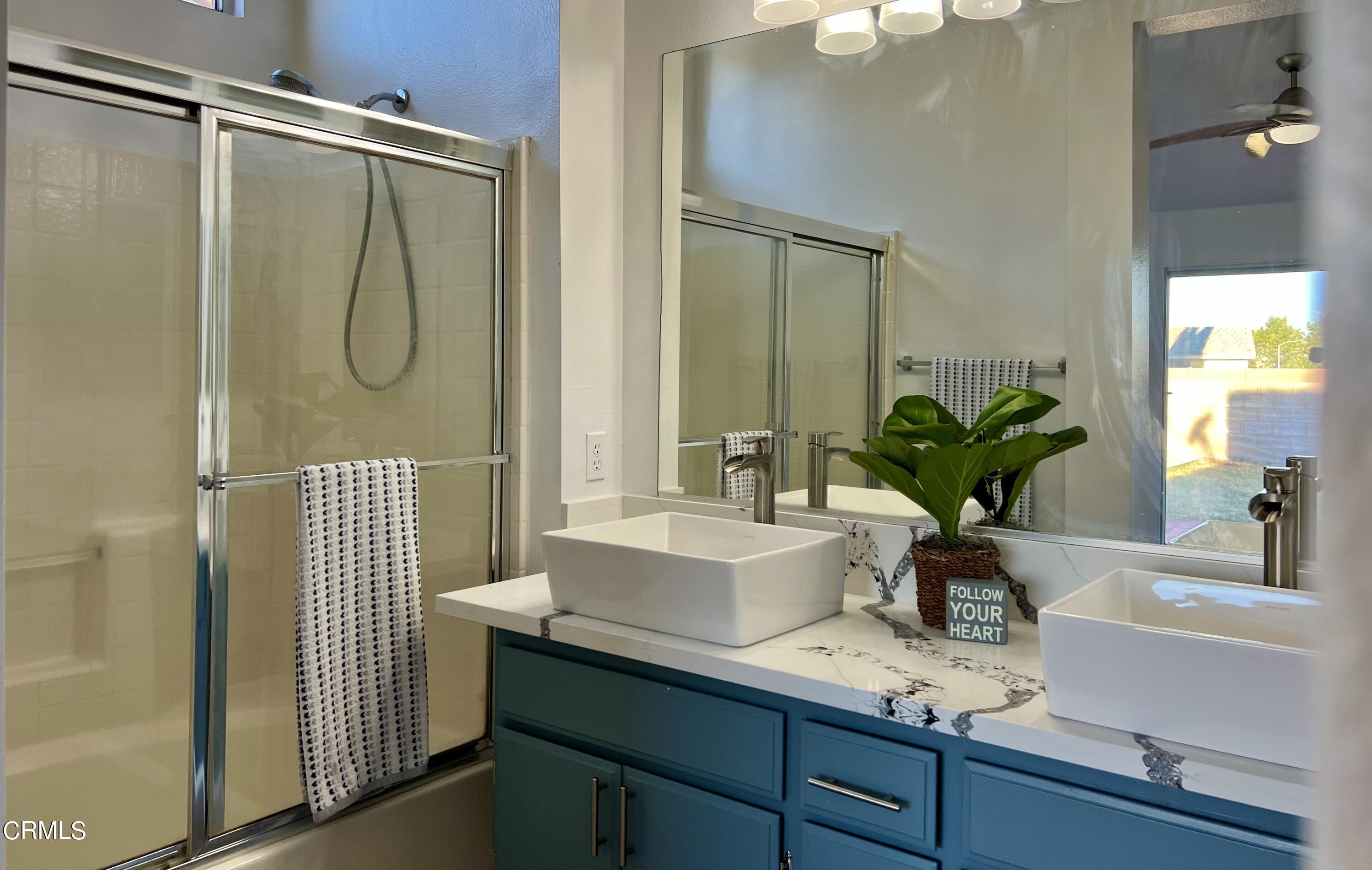 44762 Shadowcrest Drive Lancaster, CA 93536 - Photo 17 of 31 a bathroom with a sink a mirror and a shower