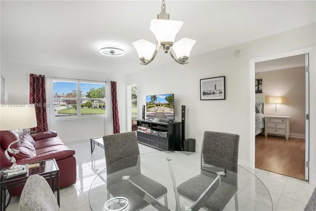 a view of a dining room with furniture a chandelier and wooden floor