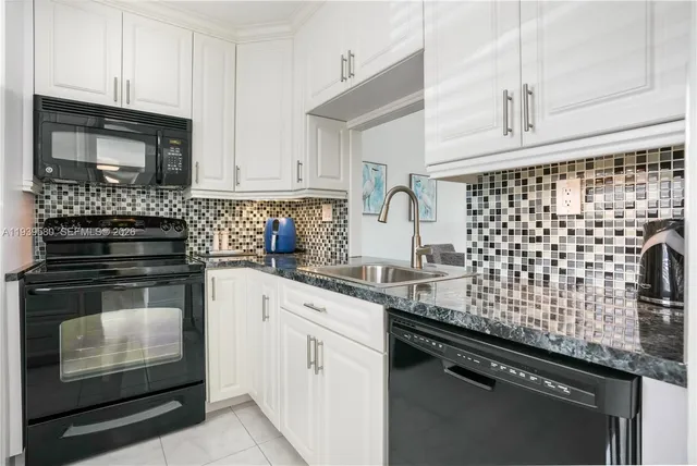 a kitchen with granite countertop stainless steel appliances and refrigerator
