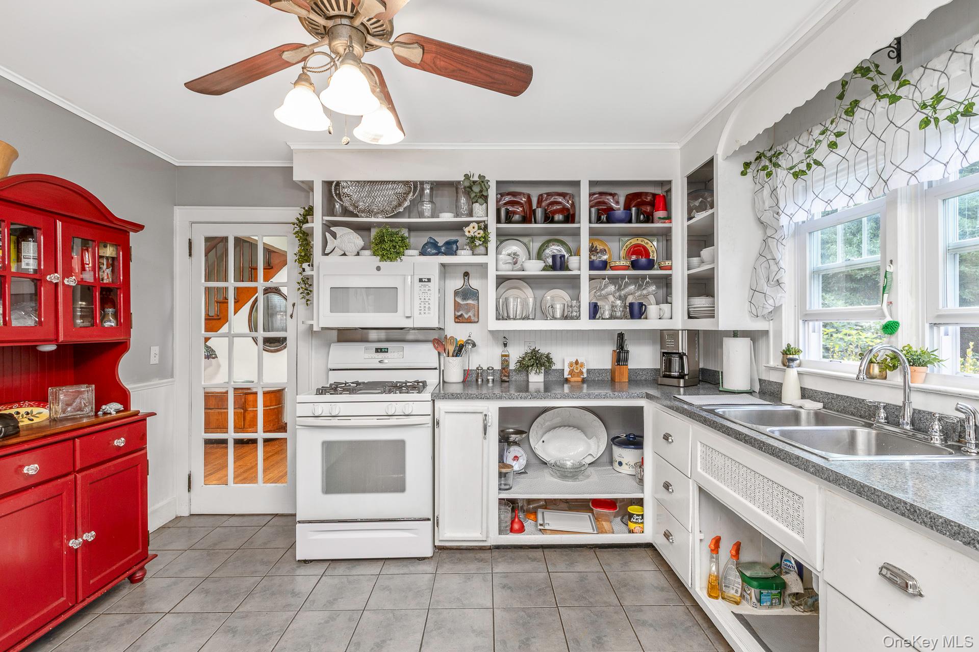 5660 Sound Avenue Mattituck, NY 11952 - Photo 16 of 43 Kitchen with open shelves, white appliances, crown molding, white cabinets, and light tile patterned flooring