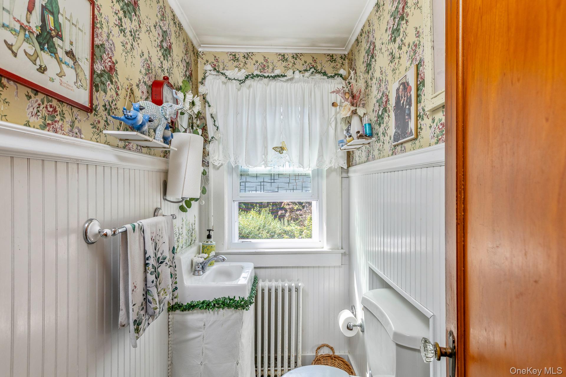 5660 Sound Avenue Mattituck, NY 11952 - Photo 24 of 43 Half bathroom with wallpapered walls, radiator, healthy amount of natural light, a wainscoted wall, and crown molding