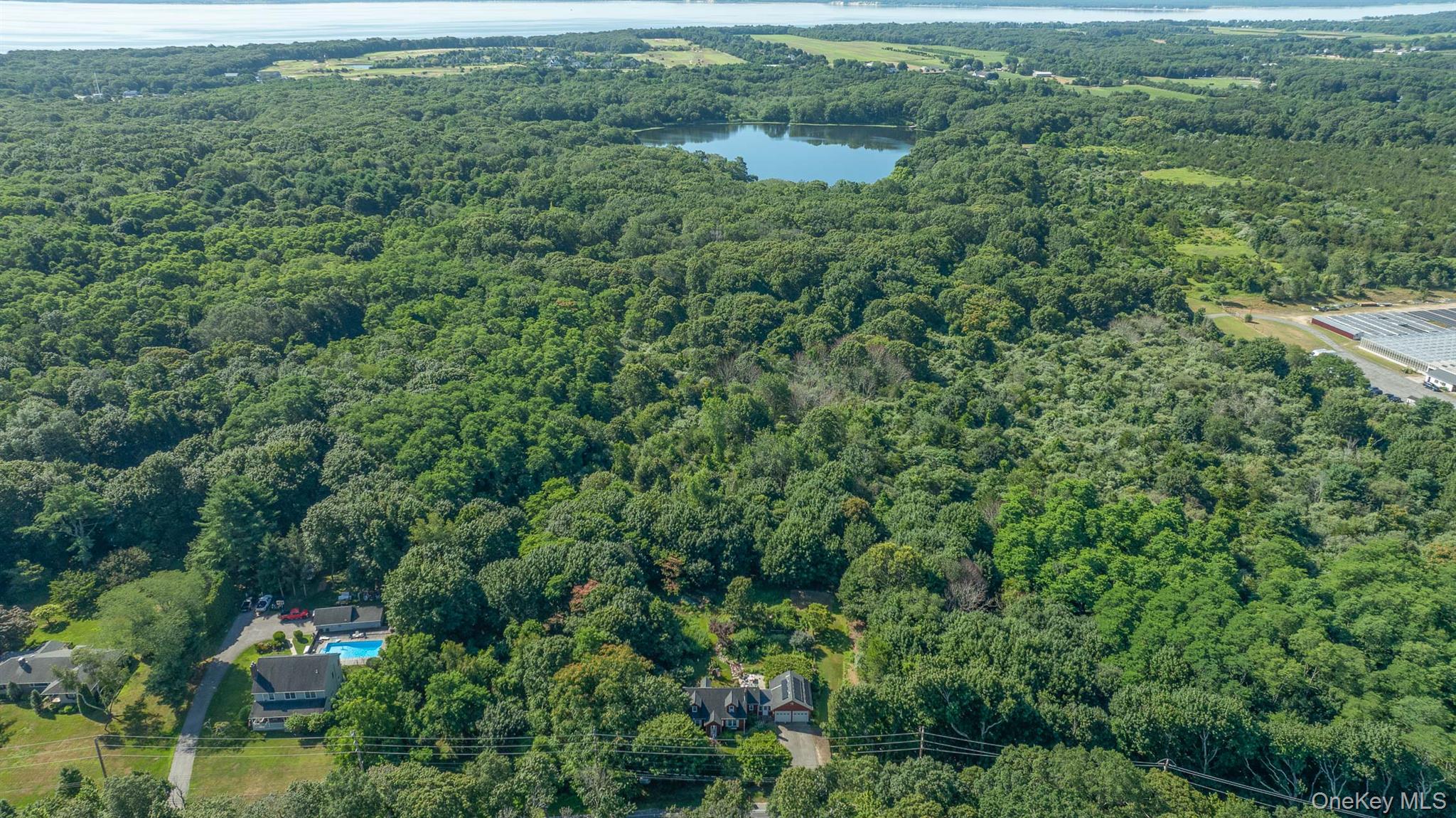5660 Sound Avenue Mattituck, NY 11952 - Photo 39 of 43 Aerial overview of property's location with a heavily wooded area and a nearby body of water