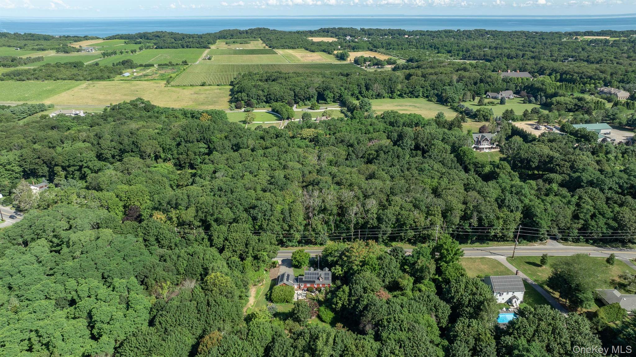 5660 Sound Avenue Mattituck, NY 11952 - Photo 42 of 43 Aerial view of property and surrounding area with a heavily wooded area and rural landscape