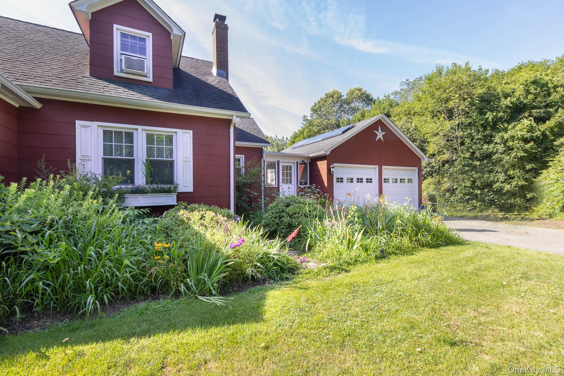 5660 Sound Avenue Mattituck, NY 11952 - Photo 6 of 43 View of property exterior featuring a chimney, a shingled roof, a garage, and a lawn