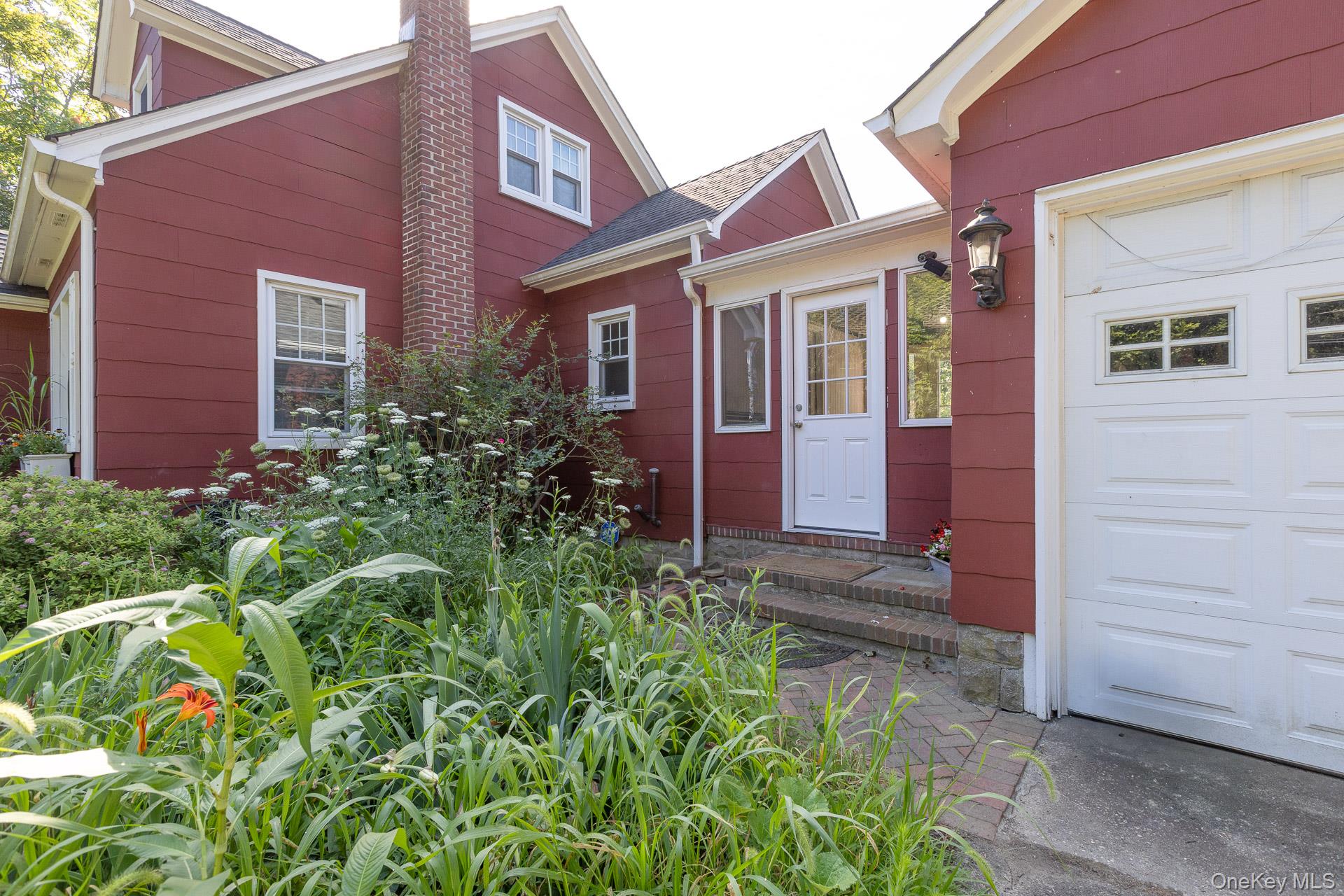 5660 Sound Avenue Mattituck, NY 11952 - Photo 7 of 43 Doorway to property featuring a chimney and a garage