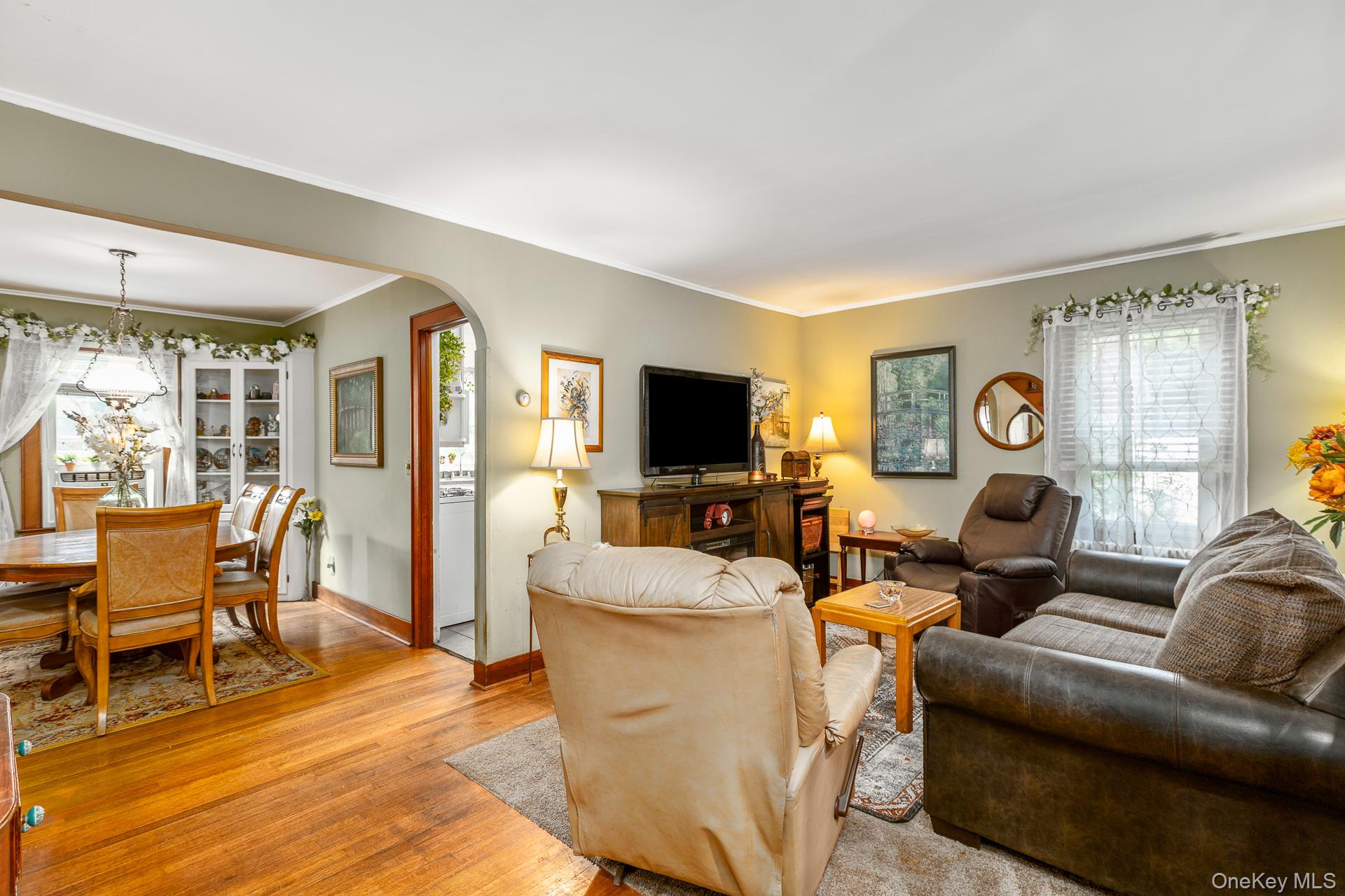 5660 Sound Avenue Mattituck, NY 11952 - Photo 10 of 43 Living area with light wood-type flooring, crown molding, and arched walkways