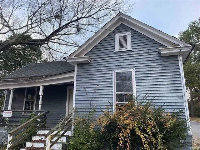 a front view of a house with plants and trees