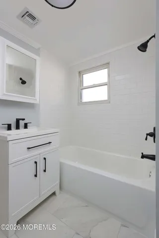 a bathroom with a bathtub sink vanity and mirror