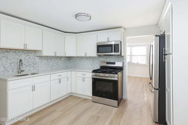 a kitchen with sink a microwave and cabinets
