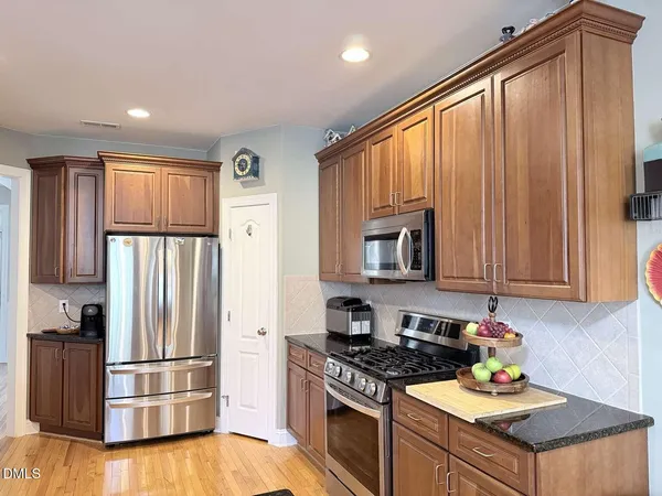 a kitchen with stainless steel appliances granite countertop a refrigerator stove and sink