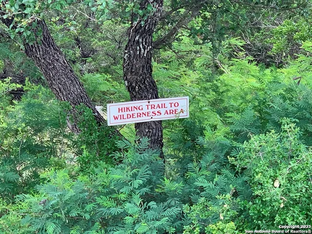 a sign that is sitting in front of a tree
