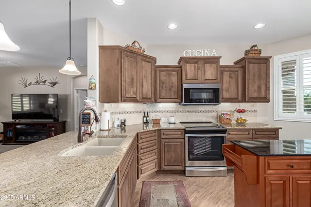 a kitchen with stainless steel appliances granite countertop a sink stove and refrigerator