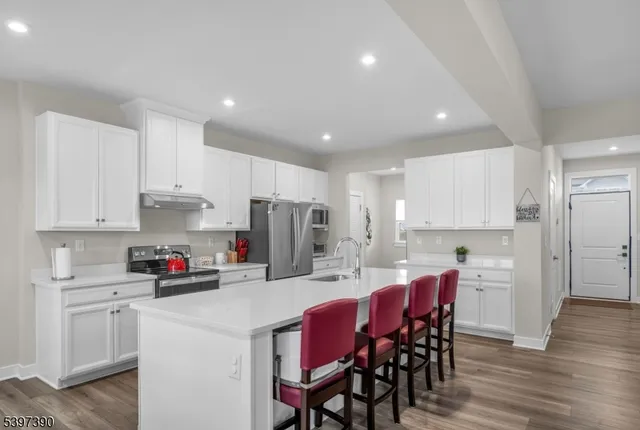 a kitchen with a dining table chairs refrigerator and cabinets