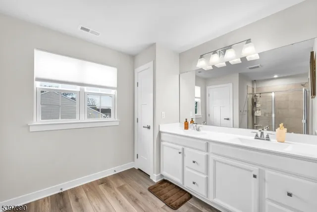a bathroom with double vanity and a mirror