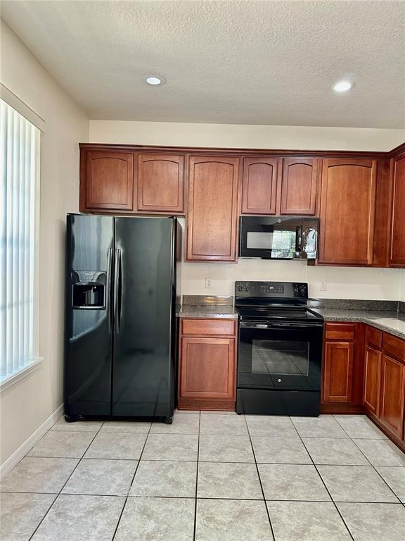 27747 Pleasure Ride Loop Wesley Chapel, FL 33544 - Photo 12 of 56 a kitchen with granite countertop a refrigerator and a stove top oven