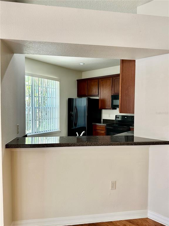 27747 Pleasure Ride Loop Wesley Chapel, FL 33544 - Photo 15 of 56 a kitchen with stainless steel appliances granite countertop a refrigerator and a stove top oven