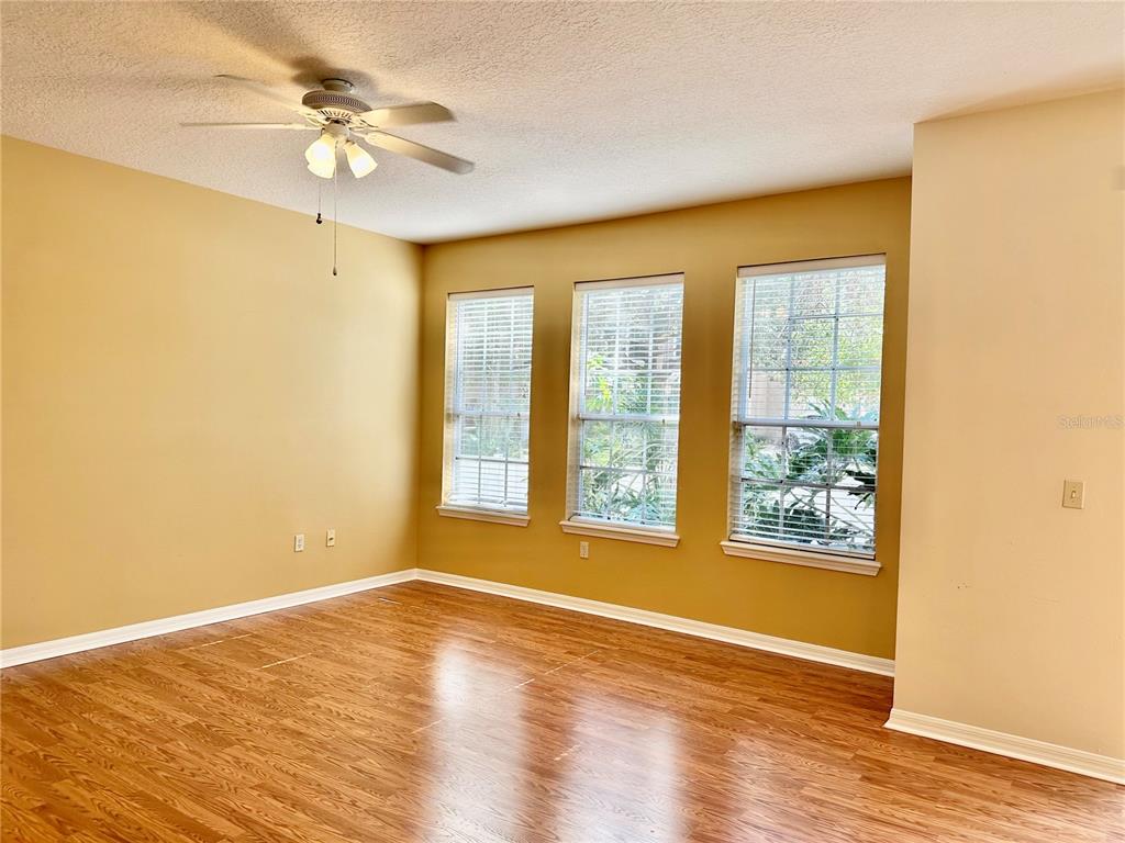27747 Pleasure Ride Loop Wesley Chapel, FL 33544 - Photo 16 of 56 a view of an empty room with wooden floor and a window