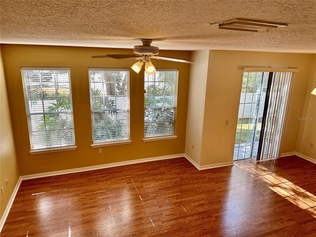 27747 Pleasure Ride Loop Wesley Chapel, FL 33544 - Photo 18 of 56 a view of an empty room with wooden floor and a window