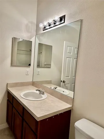 a bathroom with a sink a toilet and mirror