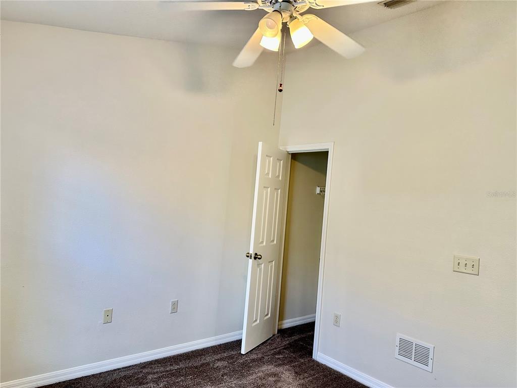 27747 Pleasure Ride Loop Wesley Chapel, FL 33544 - Photo 33 of 56 an empty room with a ceiling fan and a fan