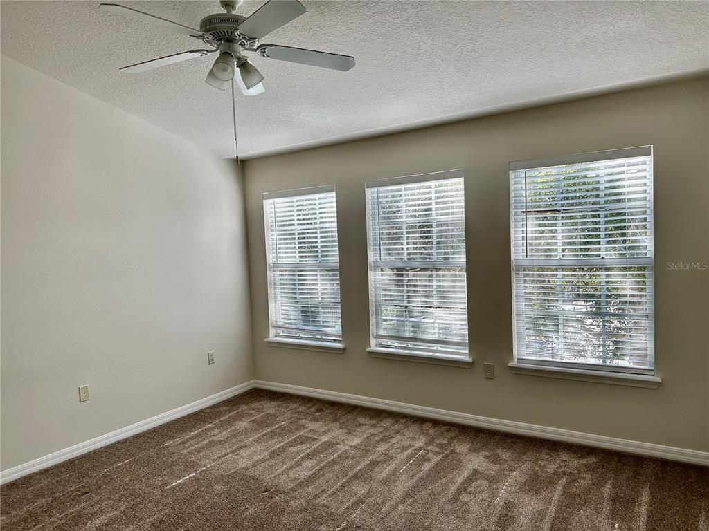27747 Pleasure Ride Loop Wesley Chapel, FL 33544 - Photo 39 of 56 an empty room with chandelier fan and windows